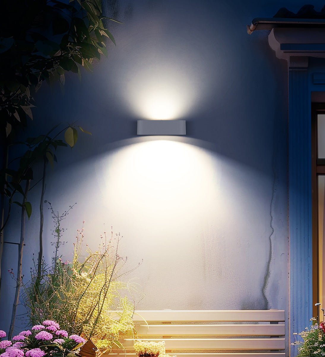 panchina posta all'esterno di una casa illuminata con un'applique solare con doppia fonte luminosa