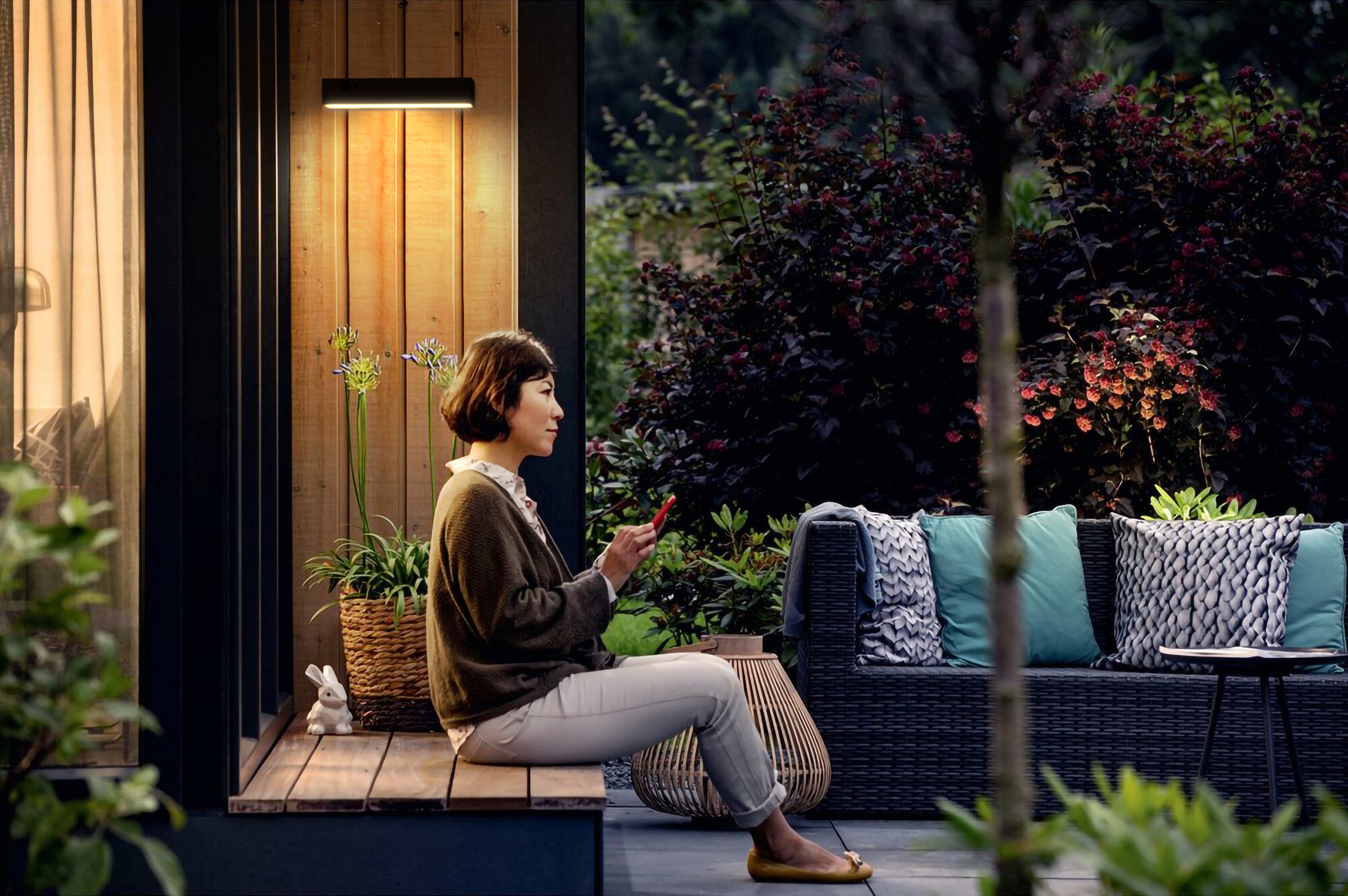 patio esterno con una persona che si sta rilassando sotto la luce di un applique ad energia solare