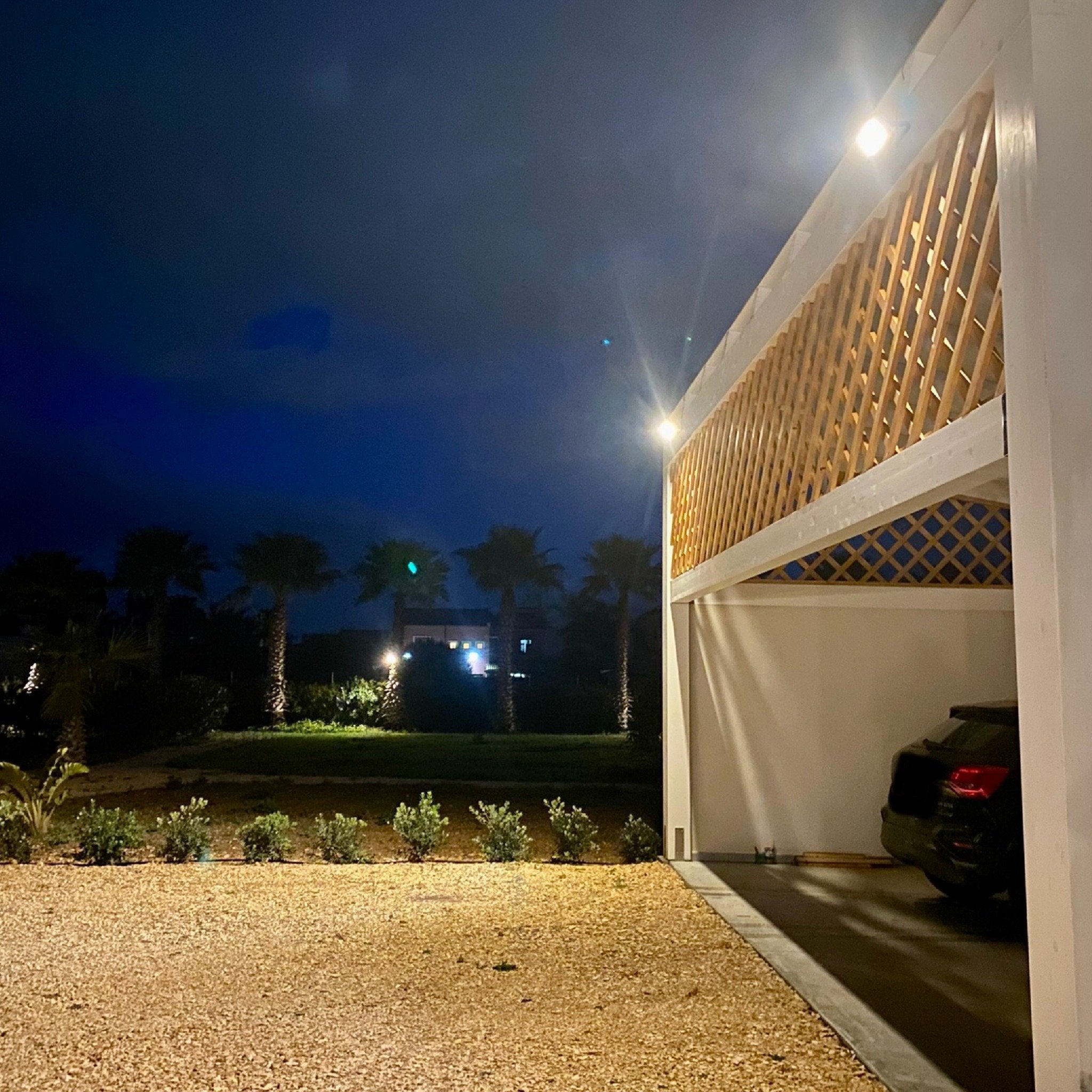 Illuminazione entrata di un garage co 2 faretti ad energia solare, con pannello solare a parte rispetto al faretto. Flusso luminoso del faretto 1100 lumen, 2 modalità di funzionamento. Disponibile sia in luce calda che fredda