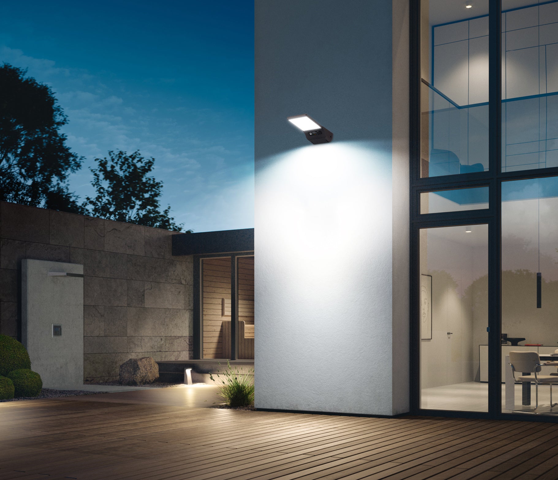 esterno di un'abitazione moderna illuminata con un lampione ad energia solare applicato a parete